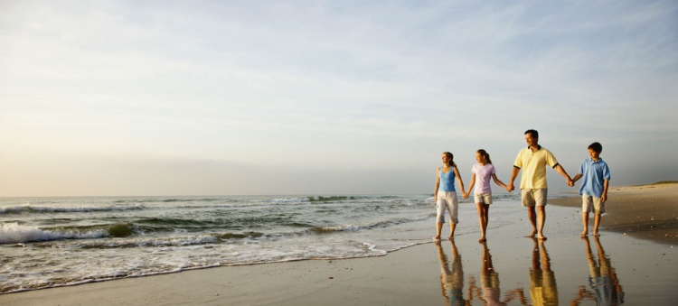 Famille qui marche sur la plage ensemble